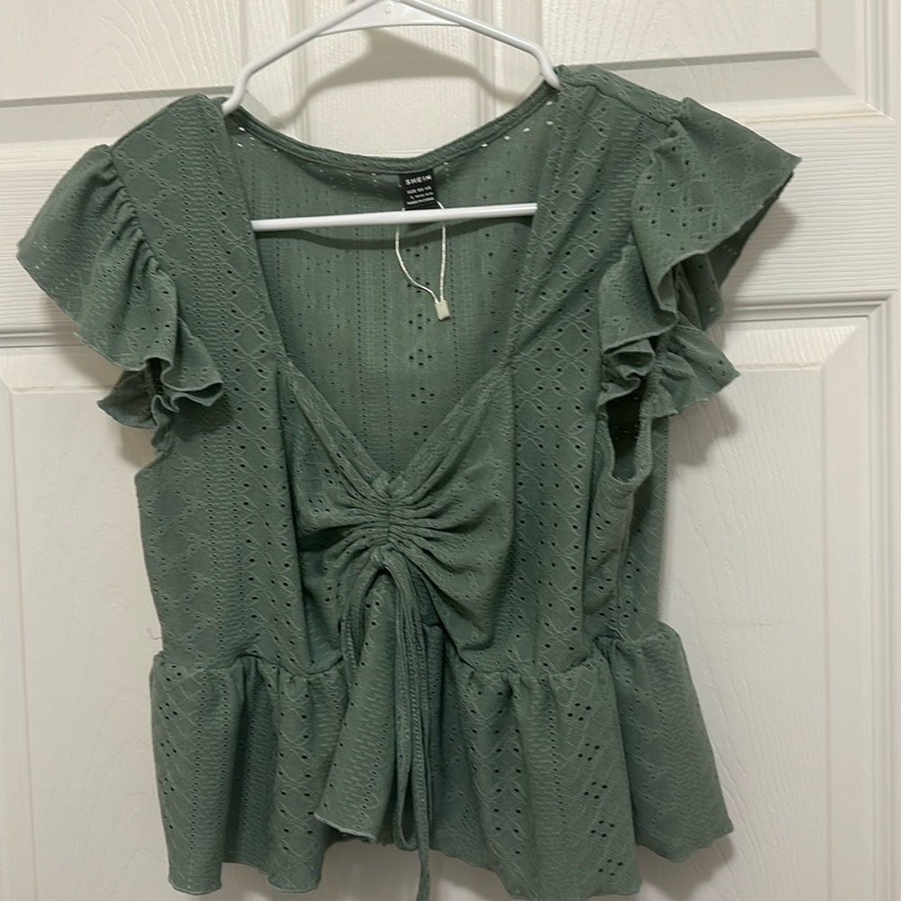 Green top with designs on it.
